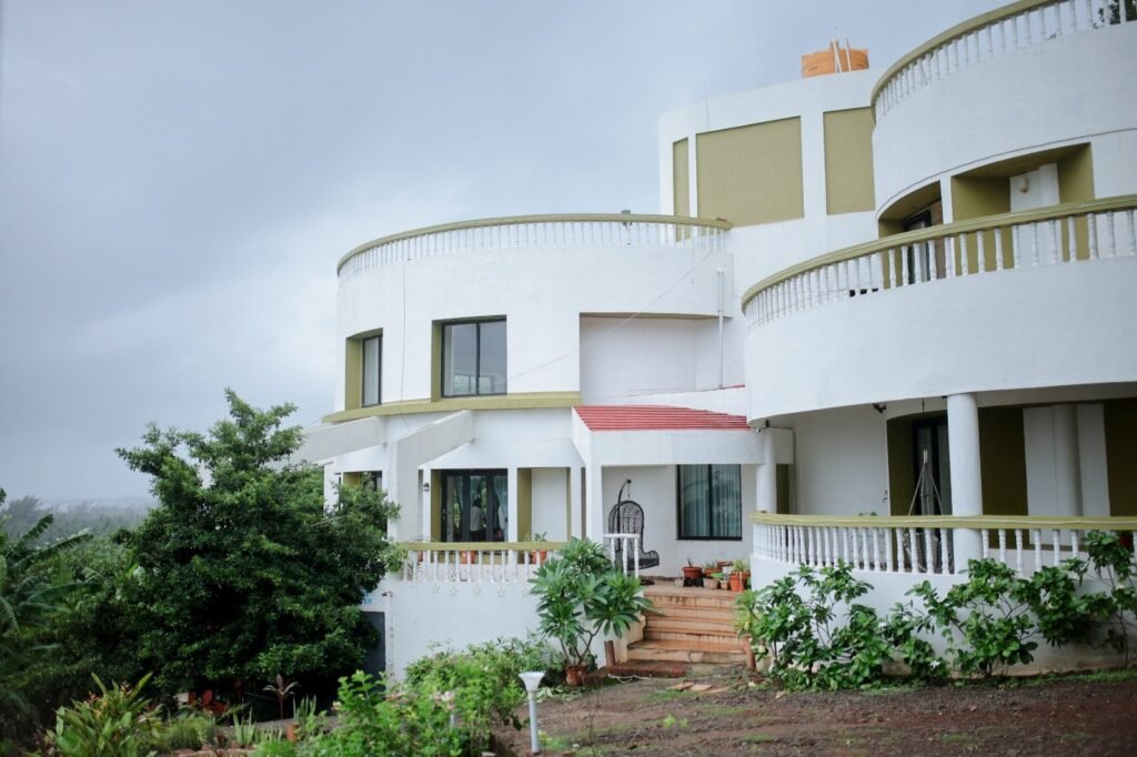 Luxury villa in Dapoli with a panoramic view of the Konkan coastline from a private balcony during sunset.